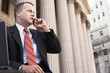 Businessman using mobile phone outside courthouse