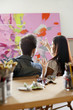 Photo: Couple discussing painting in artist's studio, back view Couple discussing painting in artist's studio, back view