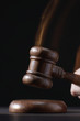 Gavel hitting base, black background