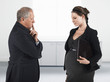 Photo: Boss talking to pregnant businesswoman, half length Boss talking to pregnant businesswoman, half length