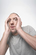 Man hunching down, covering face with hands in fear
