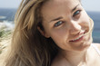 Smiling woman on beach, close-up, portrait