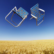 Lawn chairs over wheat field.