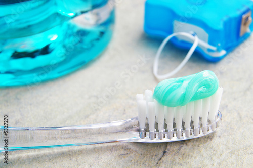 Closeup of a tooth brush, with floss and rinse