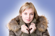 young girl in a jacket with a fur collar on a light blue backgro