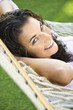 Foto: Portrait of female lying in hammock smiling up at viewer. Portrait of female lying in hammock smiling up at viewer.