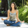 Foto: Woman sitting in lotus position practicing yoga. Woman sitting in lotus position practicing yoga.