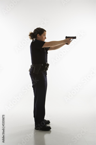 Photo: Policewoman aiming gun. Policewoman aiming gun.