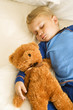 Baby sleeping with bear.