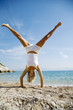 woman doing a crtwheel on the beach