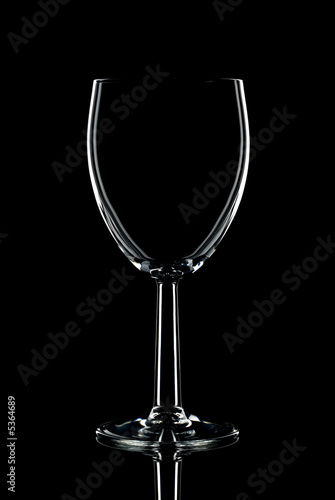 Low key shot of a single wine glass against a black background.