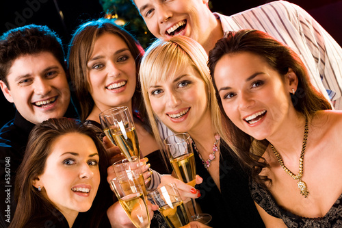 Photo: Portrait of several friends raising up their glasses Portrait of several friends raising up their glasses
