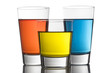 Colorful drinks on a reflective tabletop.