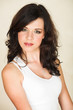 Young adult brunette woman with a white top and curly hair