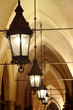 Old stylish lanterns illuminating gothic arcade