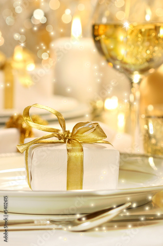 Little gold ribboned gift with gold background