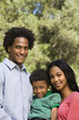 Family portrait of parents and young son smiling.