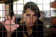 young beauty girl behind the metal bar