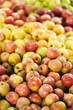 Red and yellow apples piled on table at produce market.