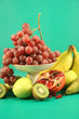 Different fruits on a green background.