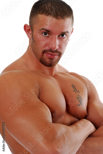 Foto: A muscular bodybuilder with his arms folded A muscular bodybuilder with his arms folded