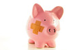Piggy bank with bandage, metaphor for healthcare costs Piggy bank with bandage, metaphor for healthcare costs