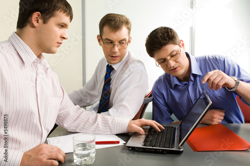 Group of three business men interacting in the office
