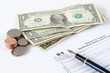 W-9 income tax form with pen and american dollars