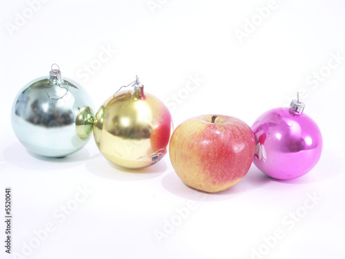 Photo: Christmas-tree decorations and apple on white background Christmas-tree decorations and apple on white background