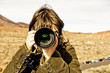 Brown haired woman taking picture.