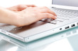Hands typing on a laptop