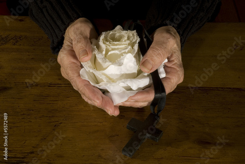 Photo: old hands with white rose and black cross old hands with white rose and black cross