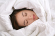 A young woman sleeping under a blanket A young woman sleeping under a blanket