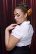 Female model with styled hair on red background.