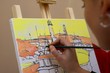 Artist at work - woman painting a picture of a ship Artist at work - woman painting a picture of a ship