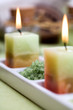 Green bath salt between two candles