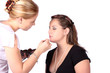 Makeup artist applying makeup to model, isolated on white 