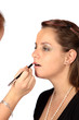 makeup artist applying lipstick to models lips