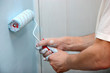 house painter using a paint roller, painting a wall in motion