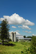 silos under a cloudy sky with foreground greenery
