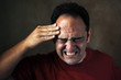 Portrait of a man in painfull expression with a headhache.