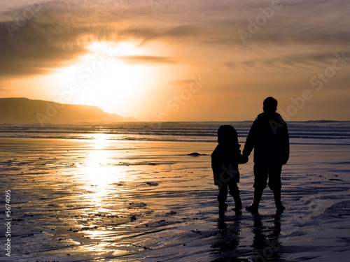 people holding hands in the sunset. Two children holding hands
