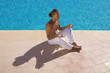 man meditating at the swimming pool side man meditating at the swimming pool side