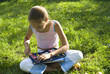The girl draws on a meadow III