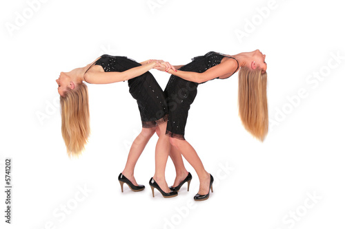 Photo: Twin girls bend behind Twin girls bend behind