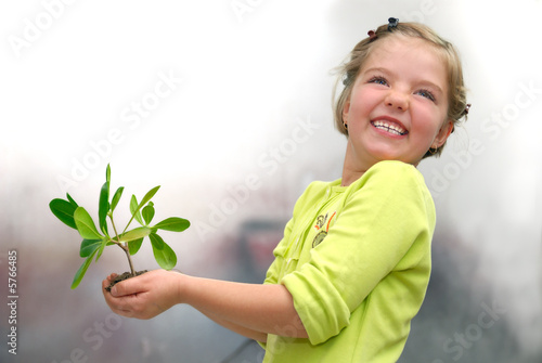 little girl holding small plant