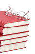 a stack of red books with glassess on it isolated