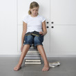 girl sitting on a stack of books girl sitting on a stack of books