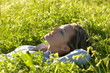 portrait of a thoughtful girl lying in the grass portrait of a thoughtful girl lying in the grass