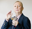 Dramatic senior woman in a man's suit holding a Martini.